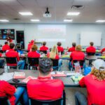 A group of people in red shirts in a classroom.