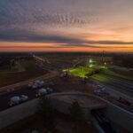 Bird's eye view of concrete trucks pouring concrete on a job site at night.