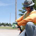 Construction workers wearing PPE and smiling as they work.