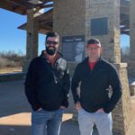 Two Crossland Construction employees posing outside.